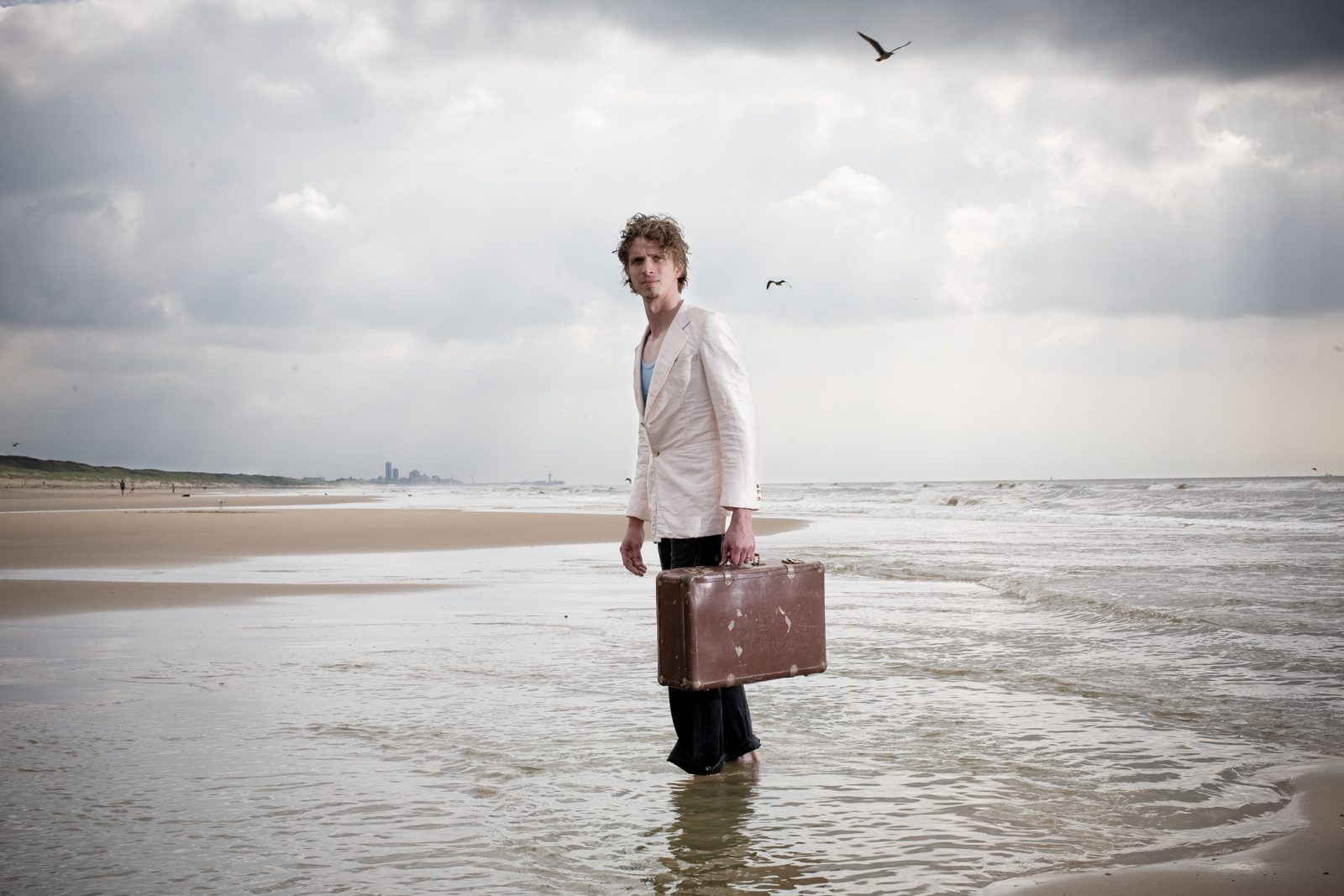 Laurens de Groot loopt met een oude koffer de zee in